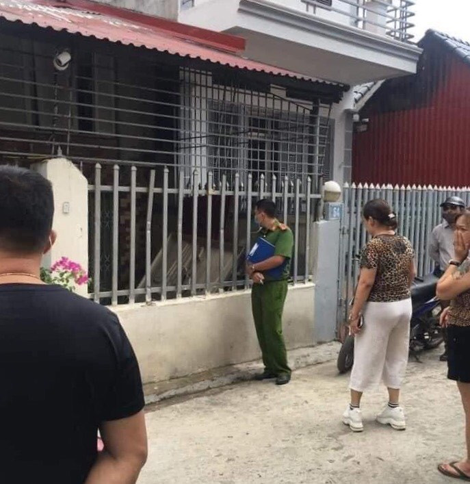 Lực lượng chức năng và người dân đứng trước cửa nhà có 2 thi thể chết bất thường nhiều hôm .Ảnh: DC