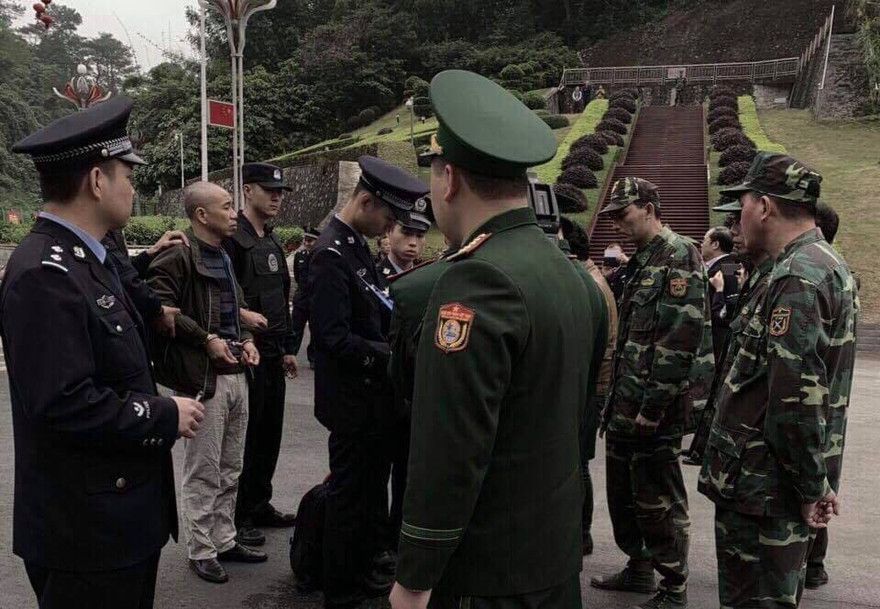 Đối tượng Thọ (thứ 2, bìa trái, đầu trọc) chuẩn bị bàn giao từ Trung Quốc về Việt Nam .Ảnh: Duy Chiến