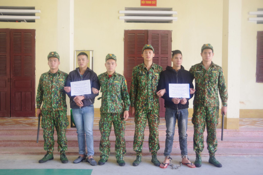 Hai đối tượng Thái và Đại (cầm biển) bị lực lượng biên phòng Tân Thanh bắt giữ khi đưa người qua biên giới trái phép .Ảnh: Duy Chiến 