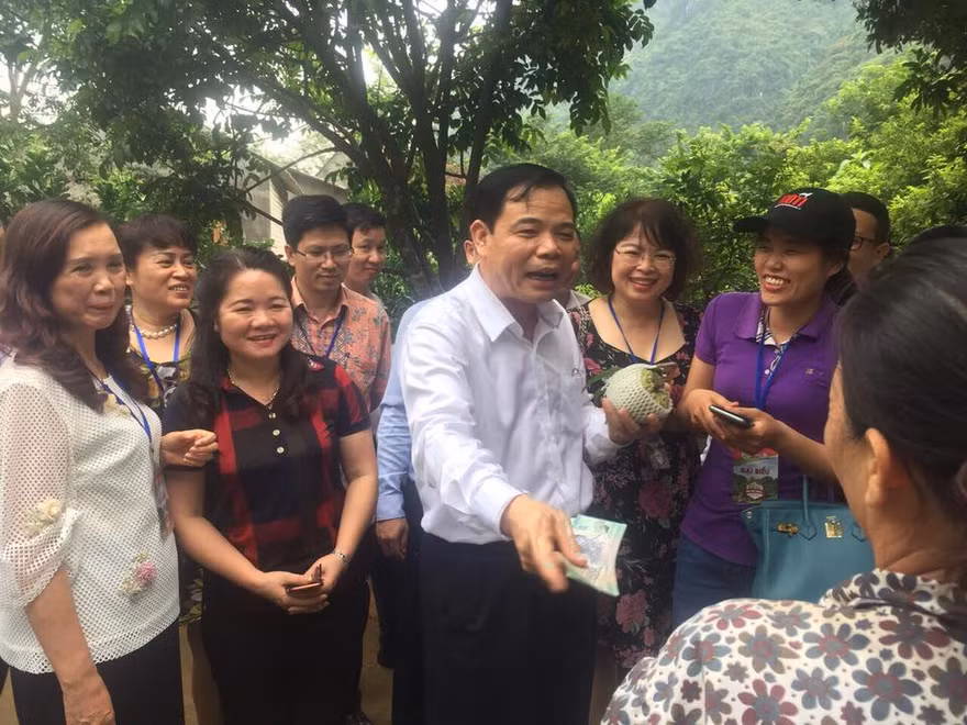 Bộ trưởng Nguyễn Xuân Cường mua na của người dân địa phương. - Ảnh: Hoàng Dự 