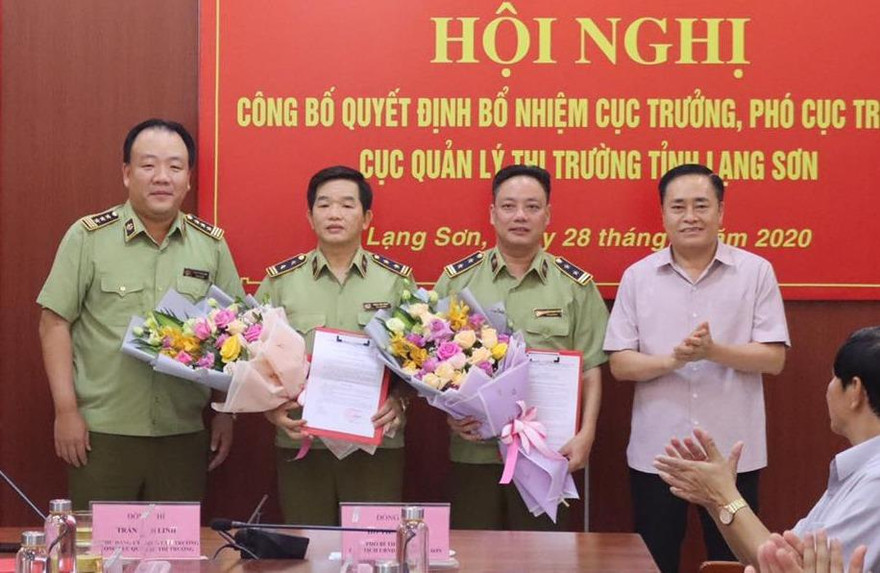 Tân cục trưởng, phó cục trưởng QLTT Lạng Sơn (giữa) nhận quyết định, hoa của lãnh đạo Tổng cục QLTT và lãnh đạo tỉnh Lạng Sơn. Ảnh: Duy Chiến
