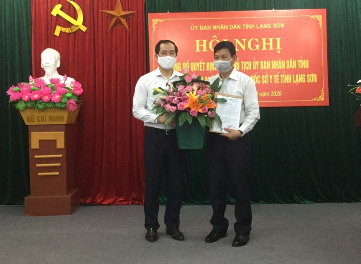 Ông Lý Kim Soi (bìa phải) nhận quyết định và hoa chúc mừng của lãnh đạo tỉnh Lạng Sơn .Ảnh: Duy Chiến