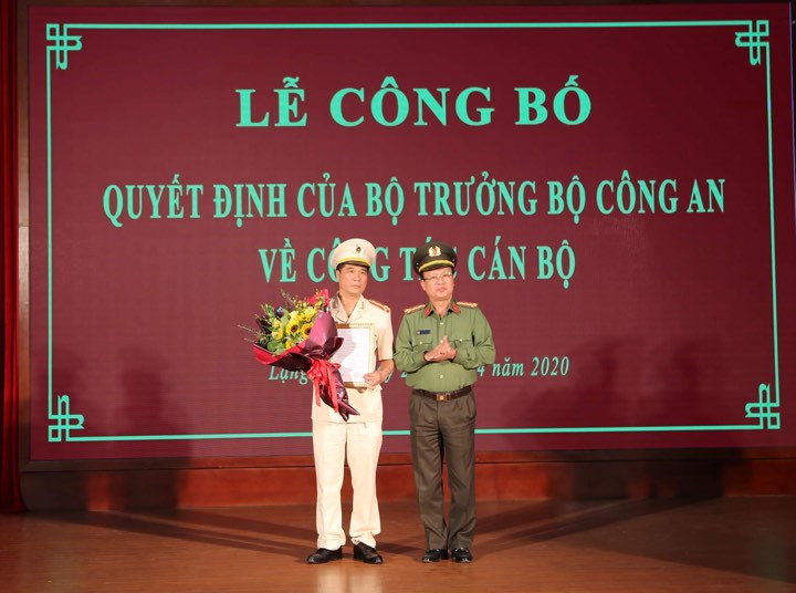 Đại tá Nguyễn Xuân Thu (bìa trái) nhận quyết định và hoa chúc mừng của đại diện lãnh đạo Bộ công an .Ảnh: Anh Khoa