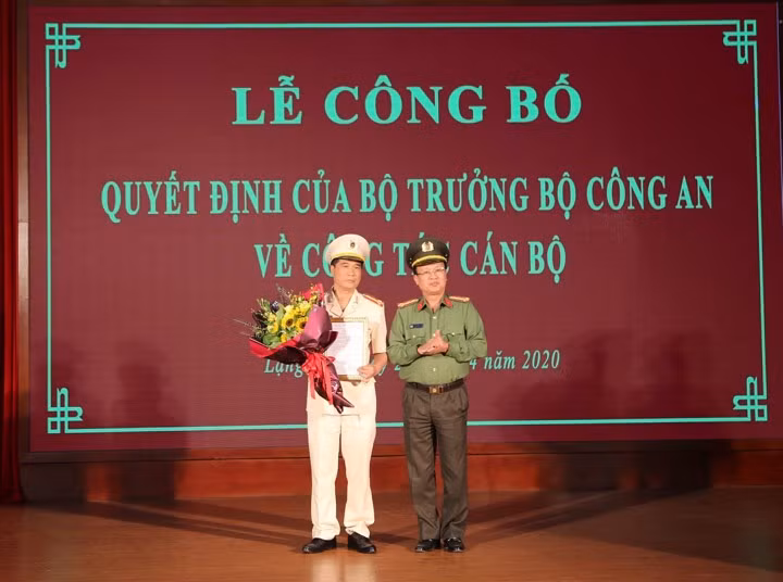 Đại tá Nguyễn Xuân Thu (bìa trái) nhận quyết định và hoa chúc mừng của đại diện lãnh đạo Bộ công an .Ảnh: Anh Khoa