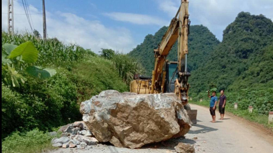 Lực lượng chức năng huy động máy móc giải tỏa tảng đá .Ảnh: V. Thương