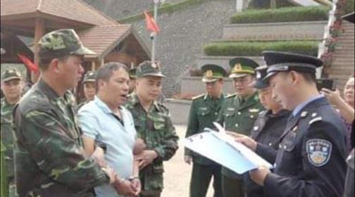 Đối tượng Xuân (giữa) trao trả cho phía Trung Quốc tại cửa khẩu quốc tế Hữu Nghị .Ảnh: TL