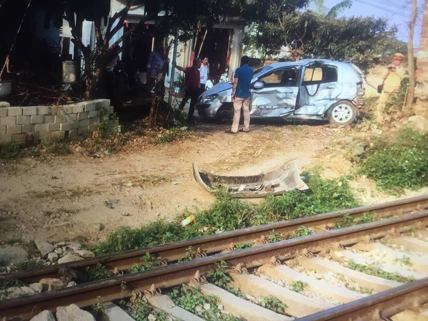 Chiếc xe ô tô bị tàu hỏa đâm, văng hàng chục mét ven đường .Ảnh: Duy Chiến