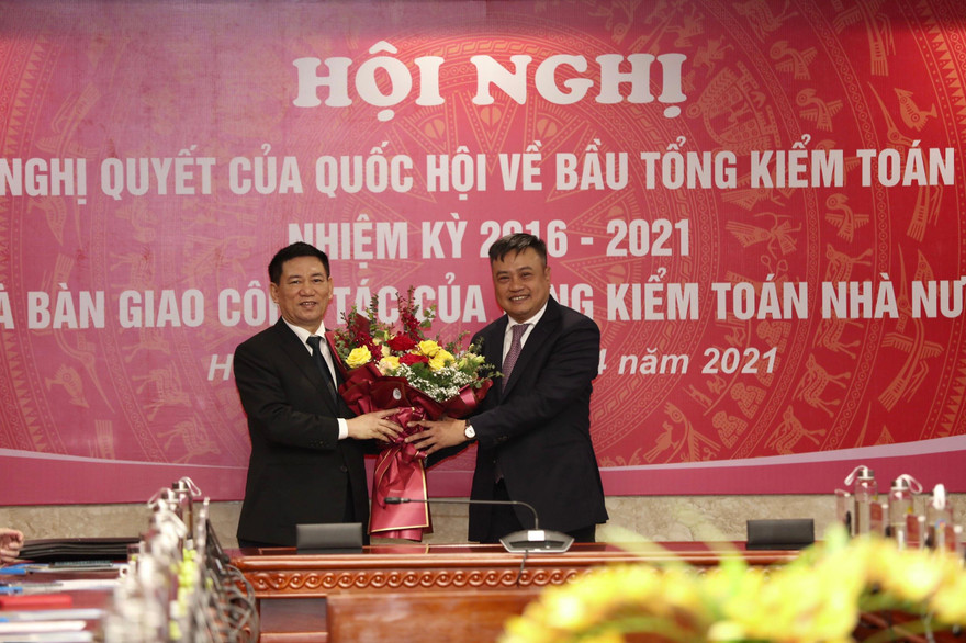 Tân Tổng Kiểm toán Nhà nước Trần Sỹ Thanh tặng hoa tân Bộ trưởng Tài chính Hồ Đức Phớc. Ảnh Như Ý 