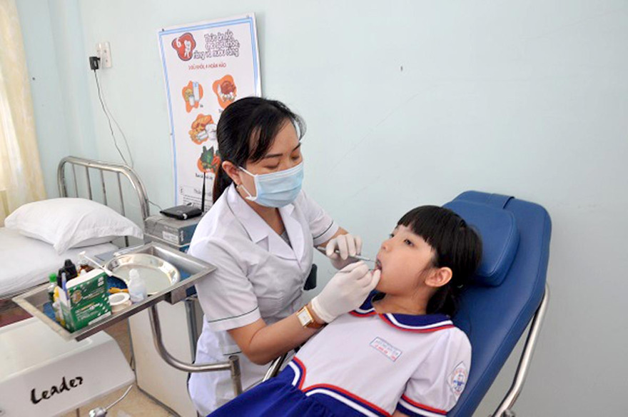 Phấn đấu toàn bộ học sinh, sinh viên trên cả nước được Bảo hiểm y tế bảo vệ sức khỏe. Ảnh chăm sóc sức khỏe ban đầu cho học sinh tại trường học.