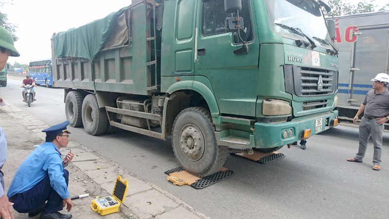 Thanh tra đường bộ dùng cân tay để cân tải trọng xe.