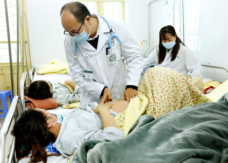 PGS. TS Đỗ Duy Cường đang thăm khám cho BN sởi điều trị tại Khoa Truyền nhiễm. Ảnh: D.Ngọc - TTX