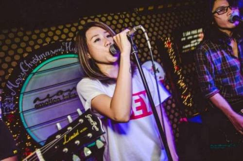 Kim Thi đang diễn cùng nhóm nhạc của mình trên sân khấu. 