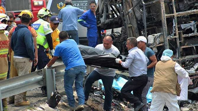 Các nhân viên cứu hộ và bác sỹ pháp y tại hiện trường vụ tai nạn xe khách với xe tải tại Mexico.