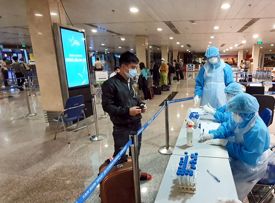 Hành khách khai báo y tế và kiểm tra sức khỏe tại sân bay Tân Sơn Nhất.