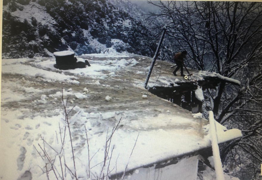 Một cậu bé đang quét tuyết trên mái nhà của mình ở Kashmir ngày 13/1.
