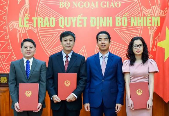 Thứ trưởng Bộ Ngoại giao Tô Anh Dũng trao quyết định và chúc mừng các cán bộ được bổ nhiệm vị trí công tác mới.