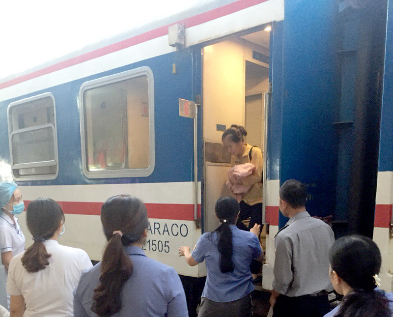 Mẹ con sản phụ được đưa xuống tàu để vào theo dõi tại bệnh viện ở ga Huế. Ảnh VNR.