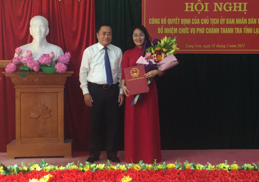 Bà Nguyễn Mai Loan (bìa phải) nhận quyết định và hoa của lãnh đạo UBND tỉnh Lạng Sơn .Ảnh: Duy Chiến 