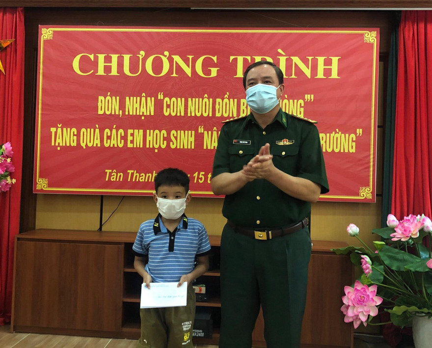 Chính ủy Bộ Chỉ huy Biên phòng Lạng Sơn Trịnh Hữu Tăng (bìa phải) tặng quà cho em Thiên Ân nhân dịp em được Đồn Biên phòng Tân Thanh (huyện Văn Lãng) nhận làm con nuôi -Ảnh: Duy Chiến 