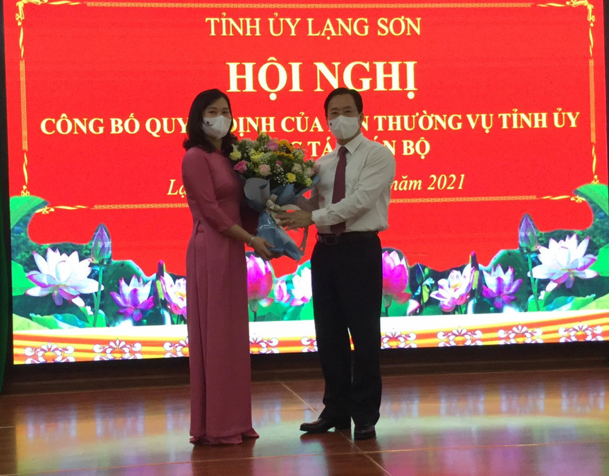 Tân Bí thư huyện ủy Chi Lăng Trần Thanh Nhàn (bìa phải) nhận Quyết định và hoa của Lãnh đạo Tỉnh ủy Lạng Sơn -Ảnh: Duy Chiến 