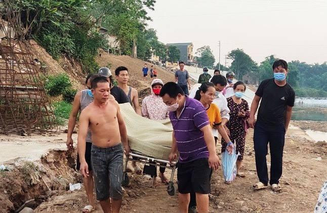 Người dân đưa thi thể bà Trang lên bờ. Ảnh: H. N