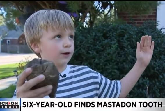 Cậu bé 6 tuổi và chiếc răng voi vừa tìm thấy.