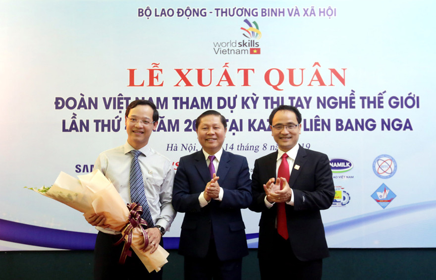 Thứ trưởng LĐ-TB&XH Lê Tấn Dũng tặng hoa cho ông Trương Anh Dũng, Phó Tổng cục trưởng Tổng cục Giáo dục nghề nghiệp - Đại biểu chính thức của đoàn Việt Nam tham dự Kỳ thi tay nghề thế giới lần thứ 45 tại Nga.