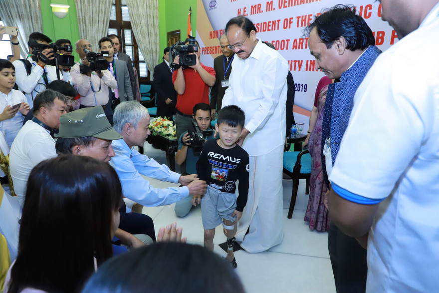 Phó Tổng thống Ấn Độ Venkaiah Naidu chứng kiến bé Tuấn Tú được lắp chân giả và đi lại bình thường. Ảnh: Như Ý