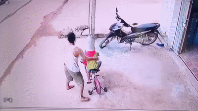 Bố nhanh tay ôm con thoát khỏi xe công nông đang lao đến