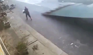 Thót tim khoảnh khắc tấm tôn lớn bay trong giông lốc suýt trúng người đi đường