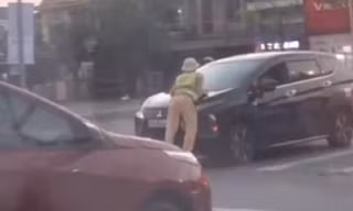 CLIP: Ô tô lao nhanh khi một cảnh sát giao thông bám trên nắp capo