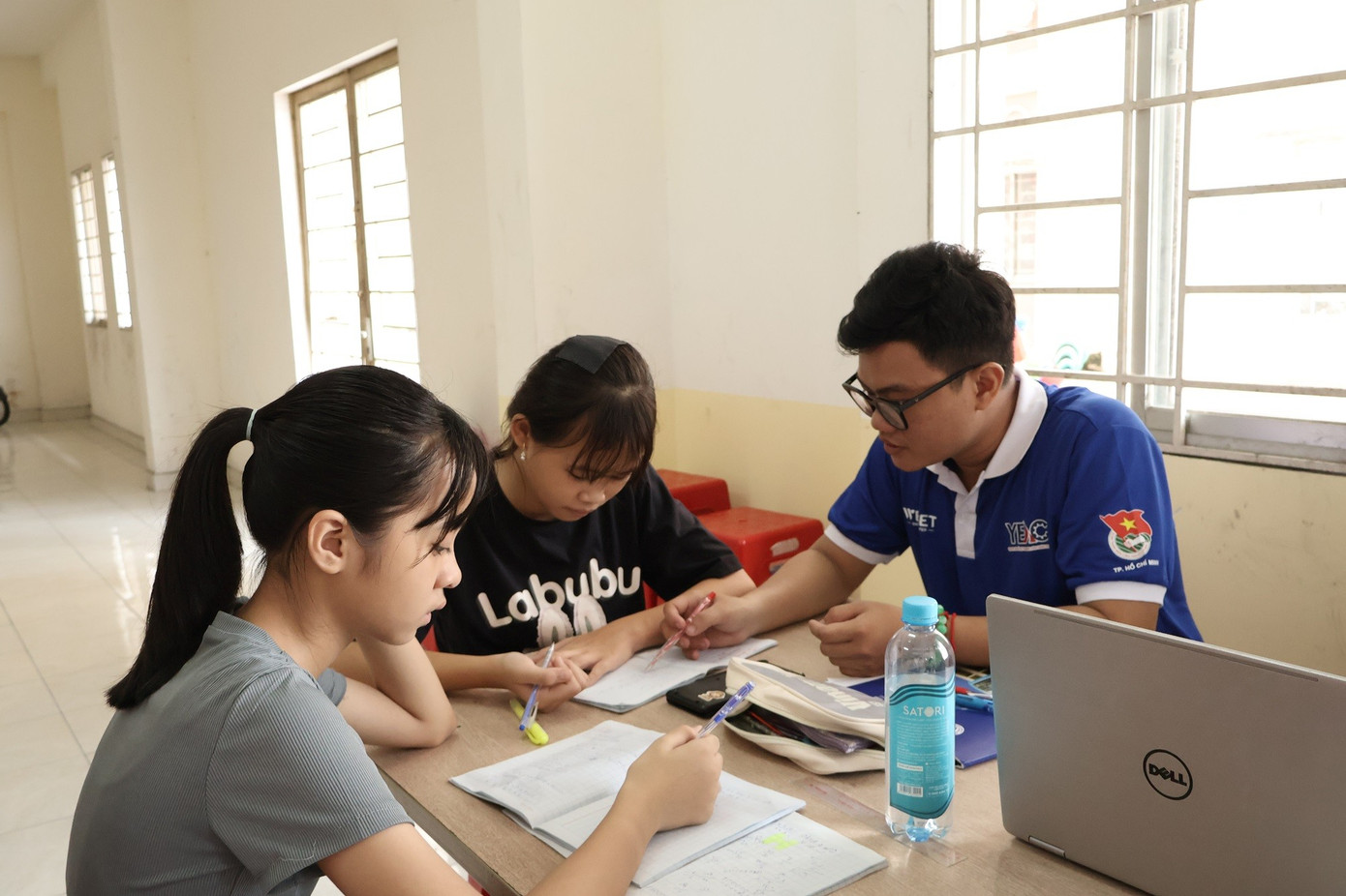 Cẩm Tú (áo đen) cùng các “Gia sư áo xanh” ôn lại những bài học. (Ảnh: Huỳnh Anh) anh-6.jpg