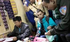 Nam thanh niên mặc áo khoác xanh, cùng các tang vật ở trên bàn liên quan đến hành vi mua bán chất ma túy bị công an bắt quả tang. Ảnh: Công an Huế