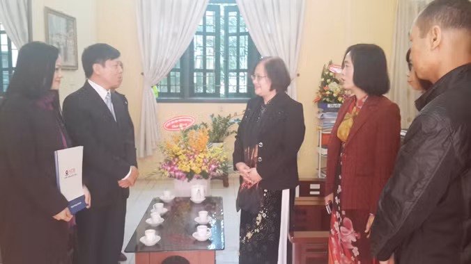 Bà Vân Hiền, giám đốc truyền thông ngân hàng Quốc Dân (NBC)- đầu tiên tay trái và ông Trần Thanh Lâm , phó tổng biên tập Báo Tiền phong trao quà cho cán bộ nhà trường.