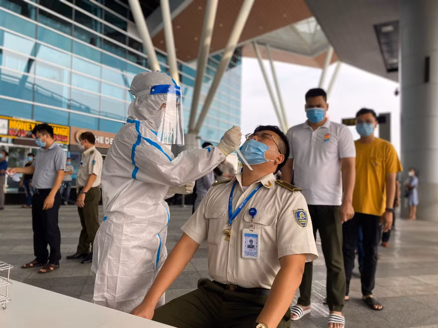 Lấy mẫu xét nghiệm SARS-CoV-2 ở sân bay Đà Nẵng. Ảnh: NLĐ