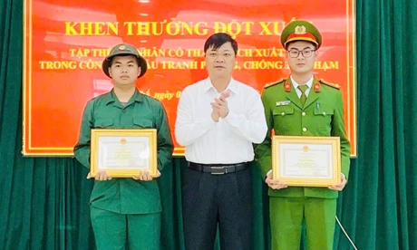 Lãnh đạo xã Yên Thế khen thưởng tân binh Vũ Tuấn Quyết (bên trái) và công an xã.
