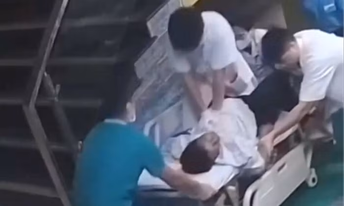 Bác sĩ trẻ ngồi trên băng ca, ép tim cứu bệnh nhân