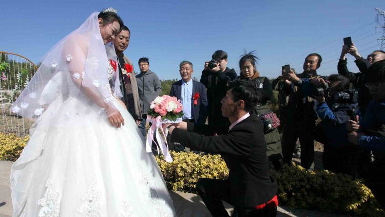 Anh Cao Mingbao quỳ gối tặng hoa vợ trong ngày cưới của hai người tại nghĩa trang ở thành phố An Sơn. Anh Cao Mingbao quỳ gối tặng hoa vợ trong ngày cưới của hai người tại nghĩa trang ở thành phố An Sơn.