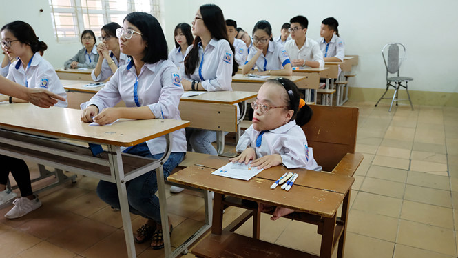 Thí sinh Phạm Thị Hoài Thương ngồi trong chiếc bàn đặc biệt tại phòng thi. ẢNH: LÃ NGHĨA HIẾU.