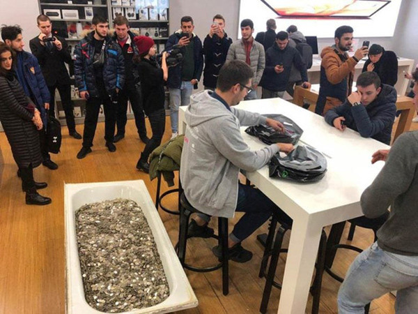 Bồn tắm chứa đầy tiền xu được nhóm thanh niên mang đến cửa hàng để mua một chiếc iPhone XS mới. Bồn tắm chứa đầy tiền xu được nhóm thanh niên mang đến cửa hàng để mua một chiếc iPhone XS mới.