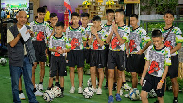 13 thành viên đội bóng Lợn Hoang bị mắc kẹt trong hang Tham Luang lần đầu tiên xuất hiện trong buổi họp báo vào tối 18/7.