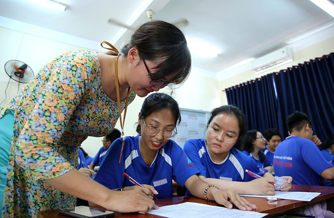 Giáo viên hướng dẫn học sinh làm hồ sơ đăng ký dự thi. ẢNH: NGỌC DƯƠNG. Giáo viên hướng dẫn học sinh làm hồ sơ đăng ký dự thi. ẢNH: NGỌC DƯƠNG.
