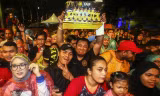 CĐV Malaysia đội mưa chờ đội nhà về nước.
