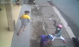 Các đối tượng xông vào chém 1 trong 2 thanh niên đi xe máy ngay trên lề đường. Hình cắt từ clip