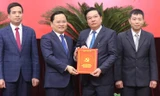 Bí thư Tỉnh ủy Bắc Ninh Nguyễn Anh Tuấn (bên trái) trao quyết định cho ông Tiếp.