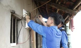 Sinh viên tình nguyện sửa điện giúp gia đình thương binh. Ảnh: Nguyễn Thắng