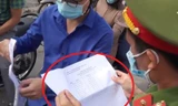 Công an Thanh Trì kiểm tra giấy đi đường có kèm lịch trực (vòng tròn đỏ) của người dân ngày 30/8, sau khi thành phố đã yêu cầu bỏ.