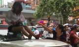 Nữ tài xế taxi mặc váy ngồi nóc ô tô chống đối CSGT
