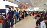 Hành khách đeo khẩu trang sếp hàng làm thủ tục tại sân bay Nội Bài. Ảnh: M.Đ