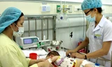 Nhân viên y tế điều trị cho trẻ mắc bệnh mùa Hè. (Ảnh: TTXVN)